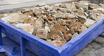 Broken up concrete in a blue bin